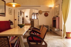 Un coin repas avec une table en bois, des chaises, un bol et un luminaire suspendu.