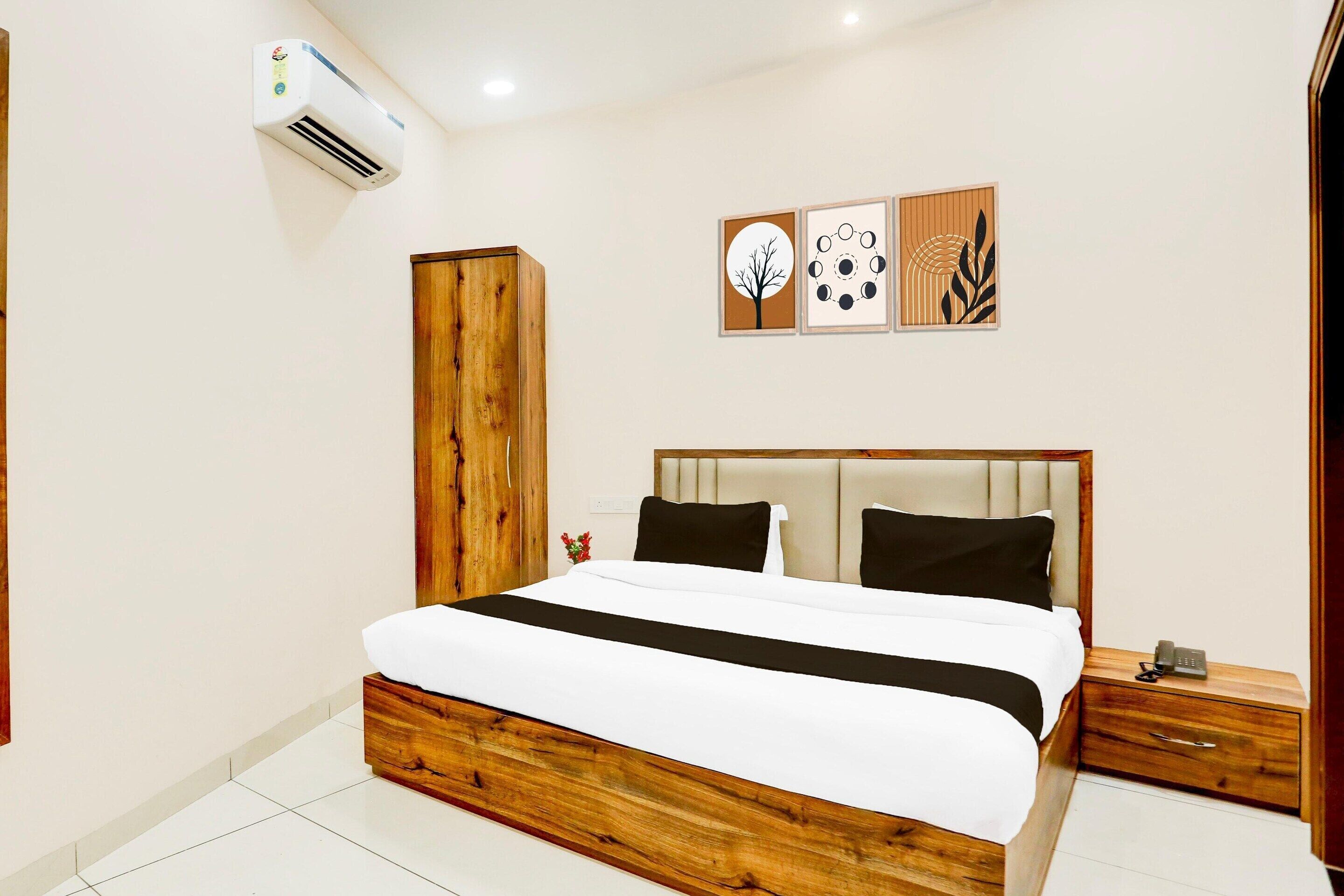 Quarto com estrutura de cama de madeira, mesa de cabeceira, guarda-roupa e decoração nas paredes.