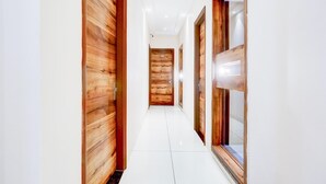 A hallway with wooden doors and a tiled floor. - Deluxe City Center Ludhiana MMC Inn (Ludhiana)