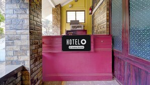 En hotellobby med en vägg av sten, ett fönster och en skylt med texten ”HOTEL O – med service från O Company”.