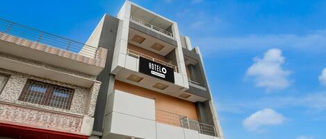 A multi-story hotel with a prominent 'HOTELO' sign, balconies, and a modern architectural design.