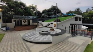 Un bâtiment moderne doté d’un sol à carreaux, d’un espace de détente circulaire et d’un escalier menant à un toit végétalisé.