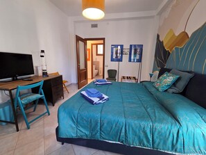 A bedroom with a bed, a desk with a computer, a chair, and a TV. - Sapore di Langhe: Holiday House in the Center with Garage (Alba)