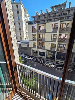 A multi-story residential building with balconies, a parking area, and a visible storefront with signage. - Sapore di Langhe: Holiday House in the Center with Garage (Alba)