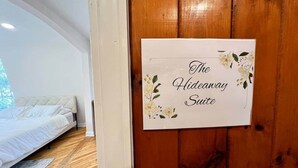 Ein Schlafzimmer mit einem Bett, Holzboden und einem Schild an der Tür.