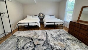 A bedroom with two beds, a wooden dresser, a mirror, and a patterned rug. - Fiddler's Roost At The Washington Inn (Fries)