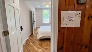 A bedroom with a bed, a ceiling fan, and a window. - River's Muse at The Washington Inn (Fries)
