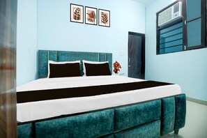 Ein Schlafzimmer mit einem Bett, einem Fenster mit Jalousien und einer Wand-Klimaanlage.