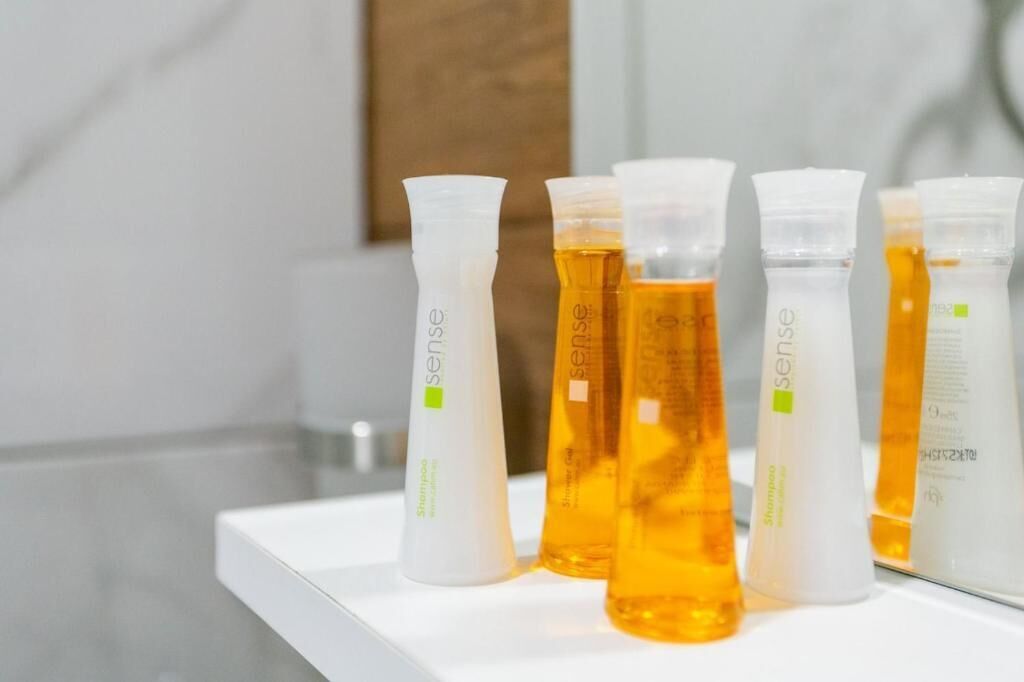 Varias botellas de champú en un estante blanco.