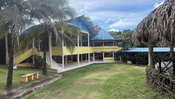A building with a blue roof, a covered walkway, and a grassy courtyard.