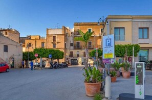 A street with buildings, a parking sign, and a parking meter. - Torre del Pardo Guest House (Sciacca)