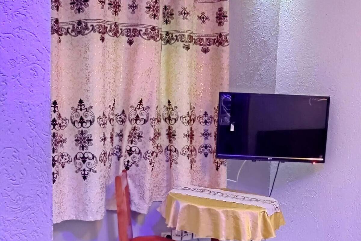 Une chambre comprenant un lit, une chaise, une table, un téléviseur et un appareil de climatisation.