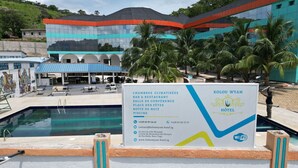 Un letrero de hotel que detalla sus servicios, incluyendo un salón de conferencias, restaurante y piscina.