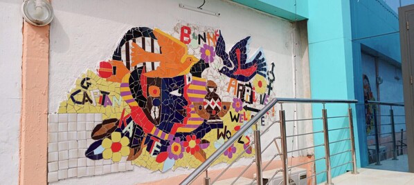 A colorful mosaic wall with the word 'WELCOME' and a bird design. - Samuel T. SANWAOGOU (Kara)