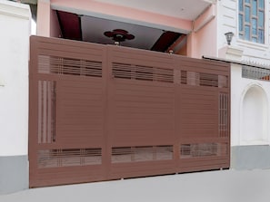 Ein großes, braunes Metalltor mit horizontalen Streben und einem zentralen Runddesign.