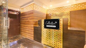 A reception area with a 'Collection' sign, a lift, and a patterned wall. - Super Deluxe Room Alambagh BM Palace (Lucknow)