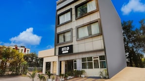 Um edifício moderno de hotel com uma placa que diz 'HOTEL' e o logotipo da marca.