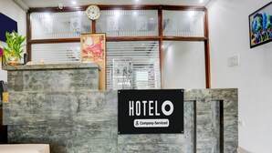 Uma mesa de recepção com uma placa que diz 'HOTEL' e 'Serviços para Empresas'.