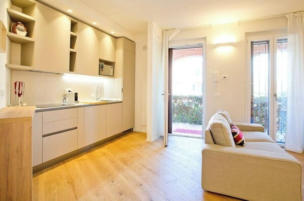 Eine moderne Küche mit integrierten Geräten, ein Essbereich mit einer Sitzecke und ein Balkon mit Blick.