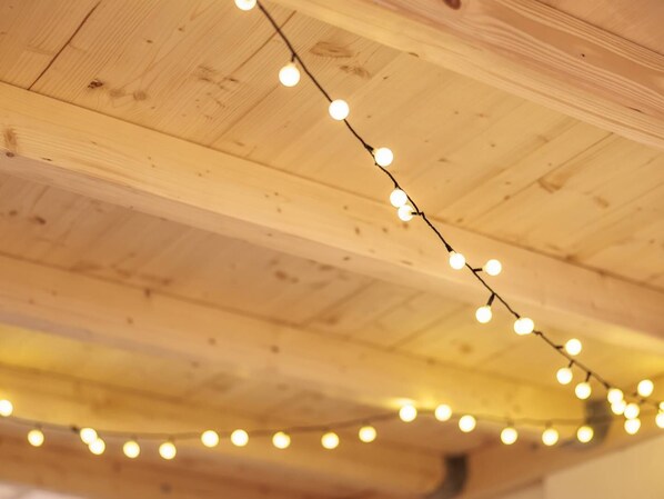 A string of lights hanging from a wooden ceiling.