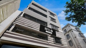 Un bâtiment d'hôtel avec une enseigne indiquant : « HOTELO Company Serviced ».