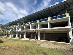 A multi-story building with a flat roof and a covered walkway. - Segundo Piso Completó (Pedro Brand)