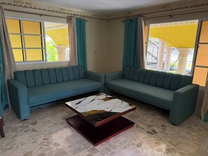 Un salón con dos sofás, una mesa de centro y un suelo estampado.