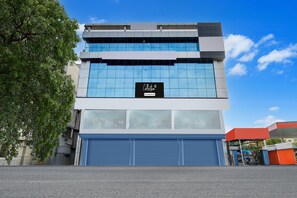 Ein modernes Gebäude mit großer Glasfassade, einem Schild mit der Aufschrift 'Collection' und einer blauen Garagentür.