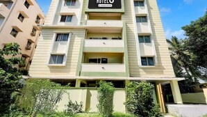 A multi-story hotel building with a sign that reads 'HOTEL Company-Serviced.' - Deluxe Sai Nivas Rushikonda (Visakhapatnam)