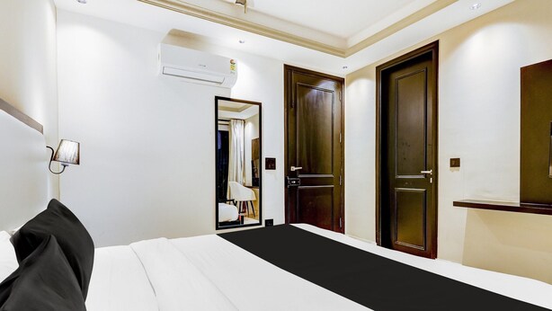 Ein Hotelzimmer mit einem Bett, einem Spiegel, einer Tür und einer Klimaanlage.