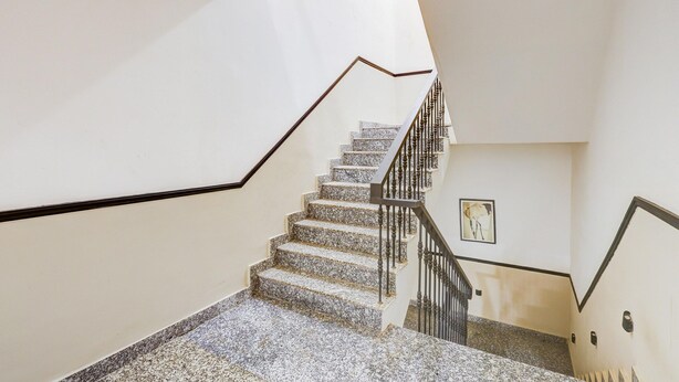 A staircase with a handrail and a picture on the wall. - Classic With Balcony Cloud Bay (Gurugram)
