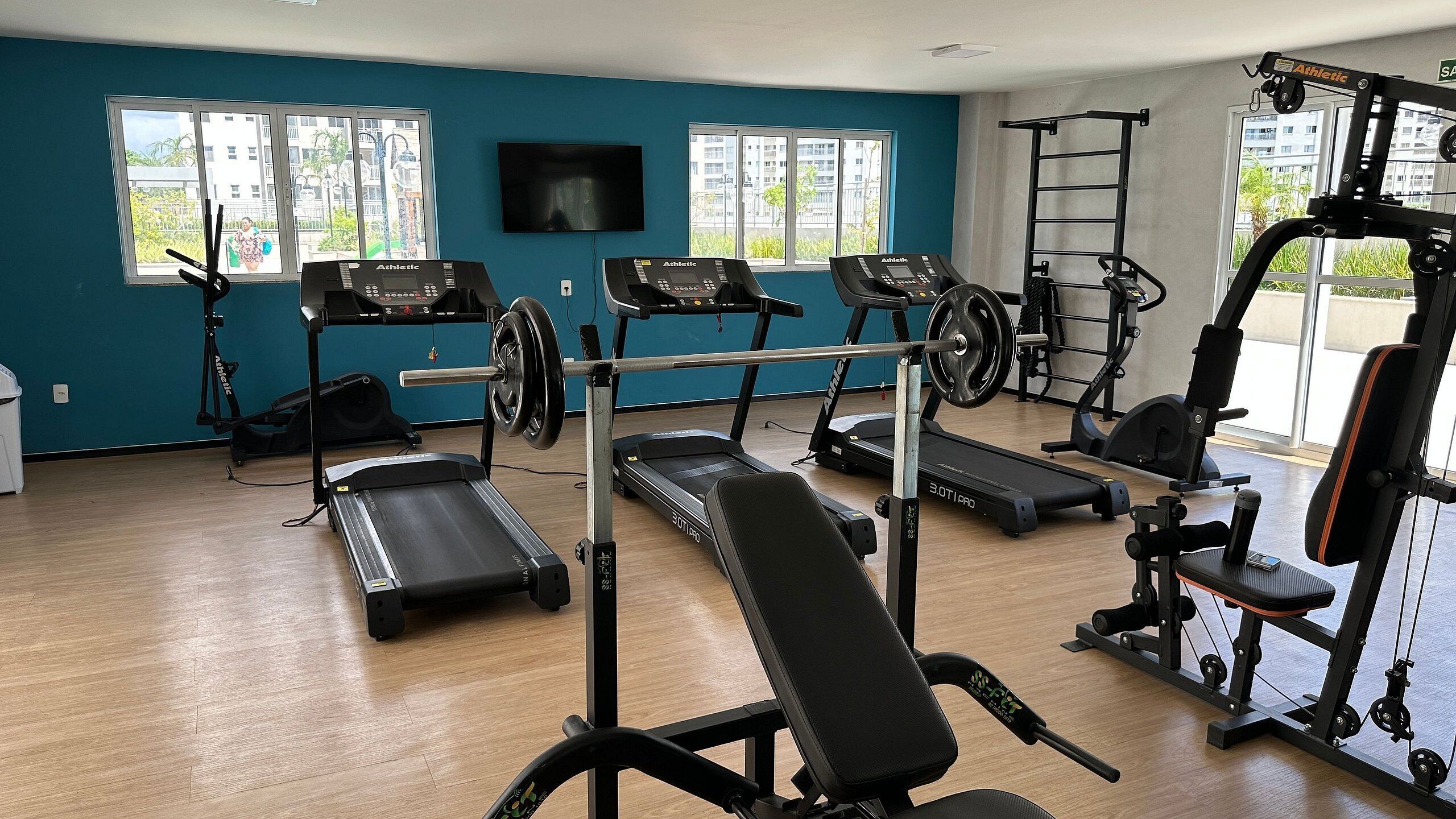 A gym with treadmills, a bench, and weightlifting equipment.