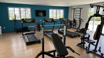 A gym with treadmills, a bench, and weightlifting equipment.