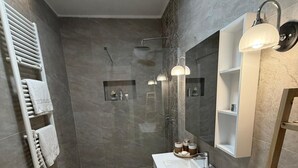 Une salle de bain moderne équipée d’une douche, de toilettes et d’un meuble-lavabo.