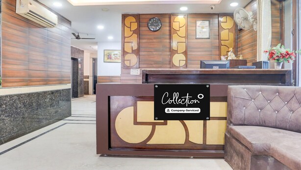 Zona de recepción con un mostrador de madera, un reloj y un sofá.