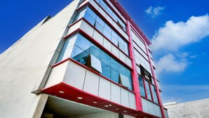 Un edificio moderno con una fachada de vidrio destacada y detalles en rojo.