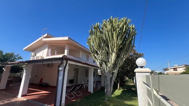 A two-story house with a covered patio, a large cactus, and a white spherical light fixture. - Seaside villa with patio, just 250 m / 3 minute walk to the beach (Sicilia)