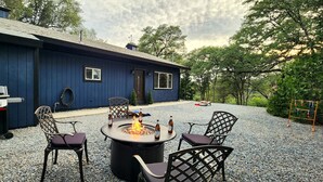 Un patio con un focolare, posti a sedere all'aperto e un barbecue.