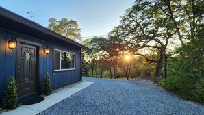 Una casa con esterno blu scuro, una porta d'ingresso, due finestre e un vialetto in ghiaia.