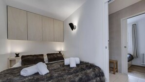 Un dormitorio con una cama grande, un armario, una mesita de noche y un aplique de pared.