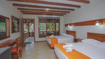 A hotel room with two beds, wooden beams, a desk, and a TV.