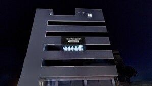 Un edificio moderno con un cartel que dice 'TOWNHOUSE' y varias ventanas.