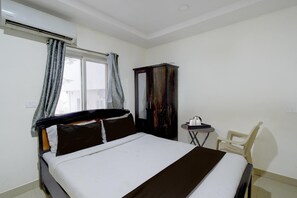 A hotel room with a bed, a wardrobe, a small table, and a chair. - Classic With Twin Bedr K Serenity Luxury Rooms (Hyderabad)
