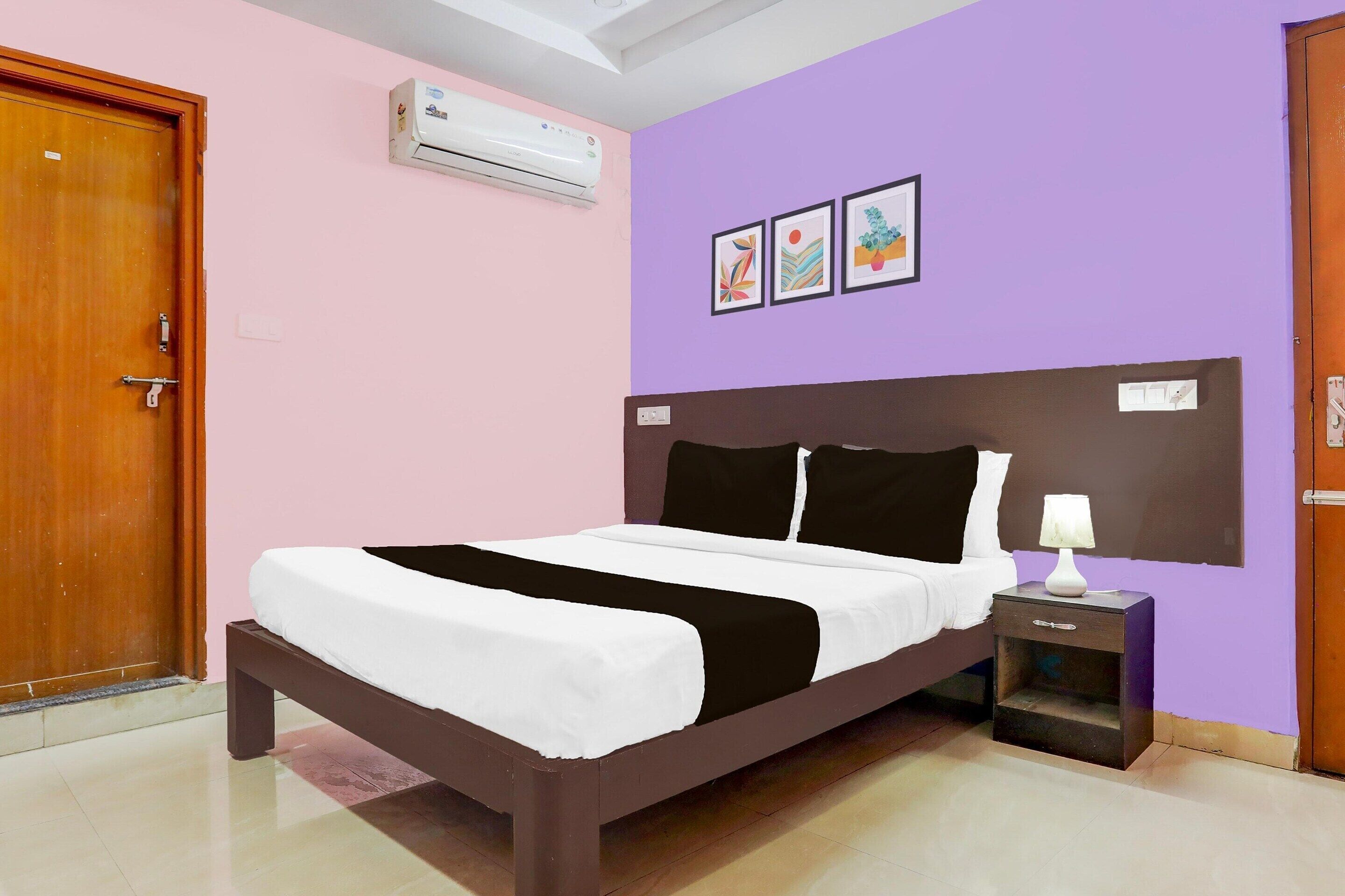 Une chambre à coucher avec un lit, une table de chevet, un climatiseur et une porte.