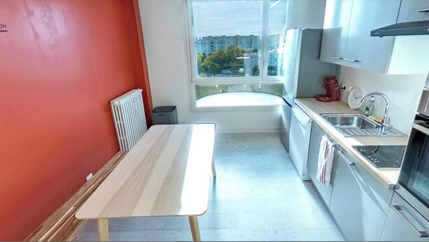 A compact kitchen with a window, a radiator, a sink, and a table. - Cozy Room in a Friendly Shared Flat - Lyon 8th (Lyon)