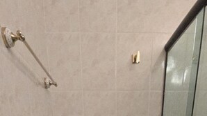 Une salle de bain équipée de toilettes, d’un bidet et d’une douche à parois en verre.