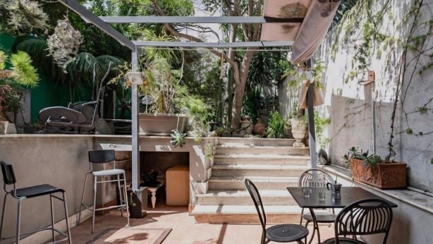 An outdoor patio with a table and chairs, a small kitchen area, and a staircase leading to a higher level. - IL NIDO DEL DUOMO, cozy apartment in the historic center with a view of the cathedral (Catania)