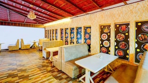 Een restaurant met houten vloeren, zachte zitplaatsen en een rood plafond.