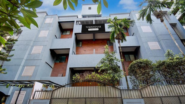 A modern townhouse with a sign reading 'TOWNHOUSE & Company Service.' - Super Townhouse Formerly Silver Crest (Pune)
