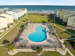 A resort with a large pool, beachfront view, and multiple guest buildings. - Bird’s Nest | Ocean View Condo w/ Balcony (Surf City)